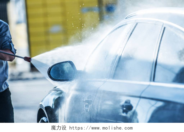 男子用水枪清洗汽车汽车电源清洗。男子用强大的压力清洗机清洗他的汽车.